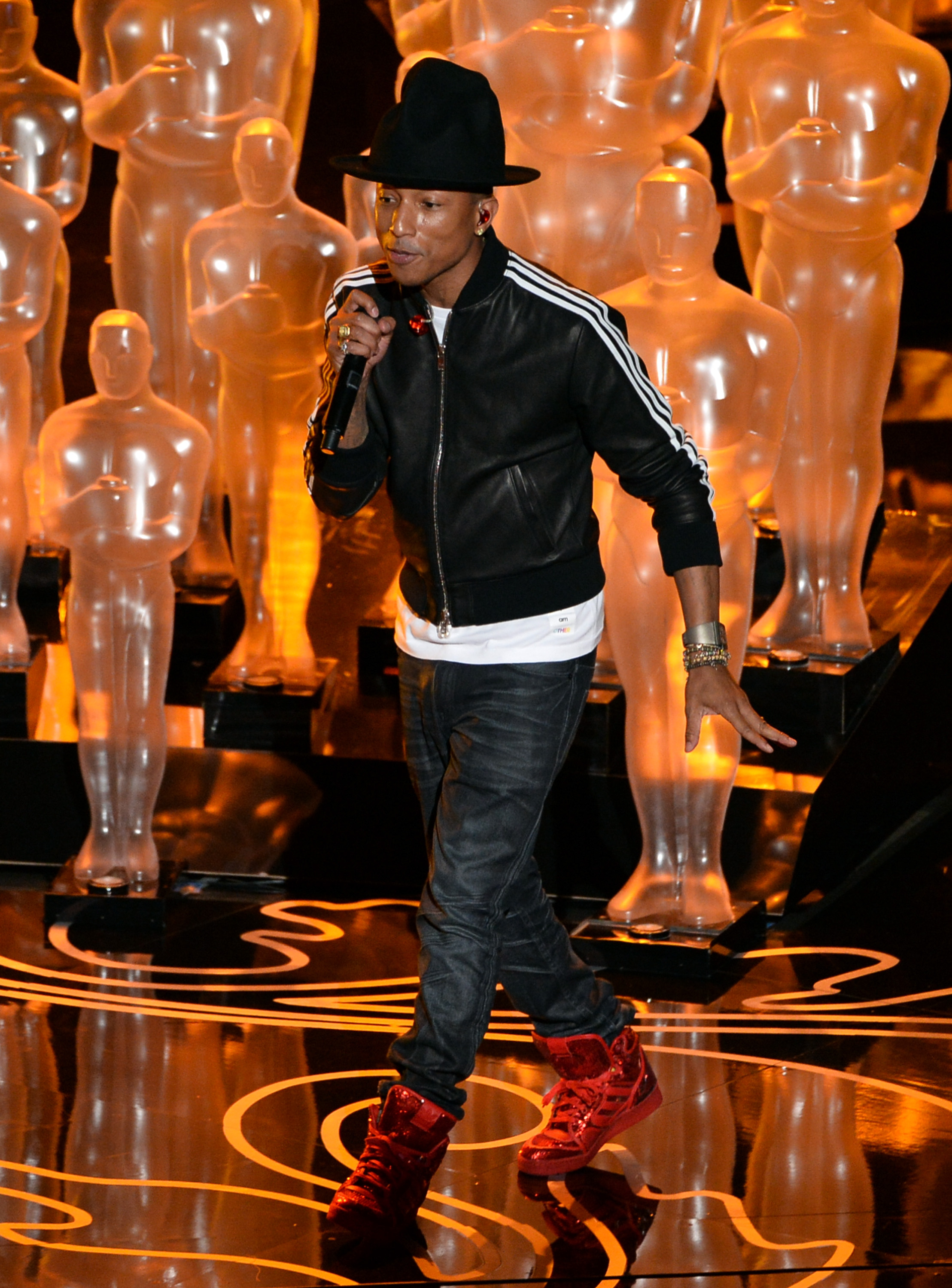 Pharrell Williams arrives at LAX in style. He wore a patchwork coat  complimented by a polka dot waistcoat with long tailed denim shirt. On his  feet he had snake skin slip-on sneakers